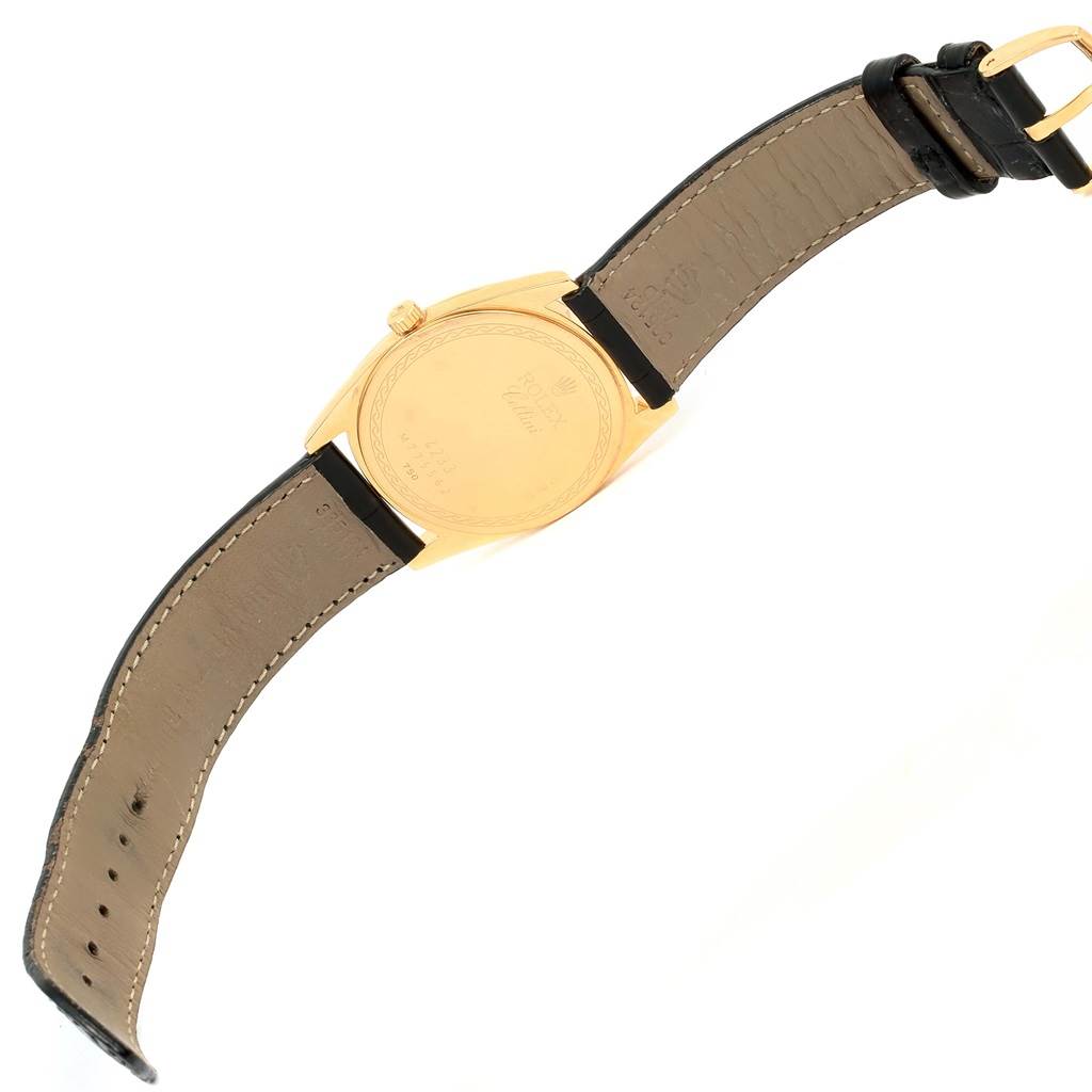 The image shows the back view of a Rolex Cellini 4233 Men's Yellow Gold White Dial 4233 Men's Yellow Gold White Dial watch, highlighting its leather strap and gold caseback.