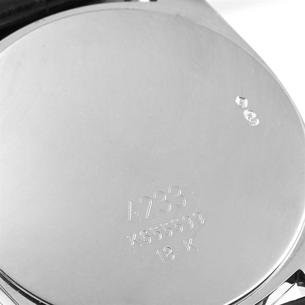 This is a close-up of the back of a Rolex Cellini 4233 White Gold Black Dial 4233 White Gold Black Dial watch, showing serial numbers and material hallmark (18K).