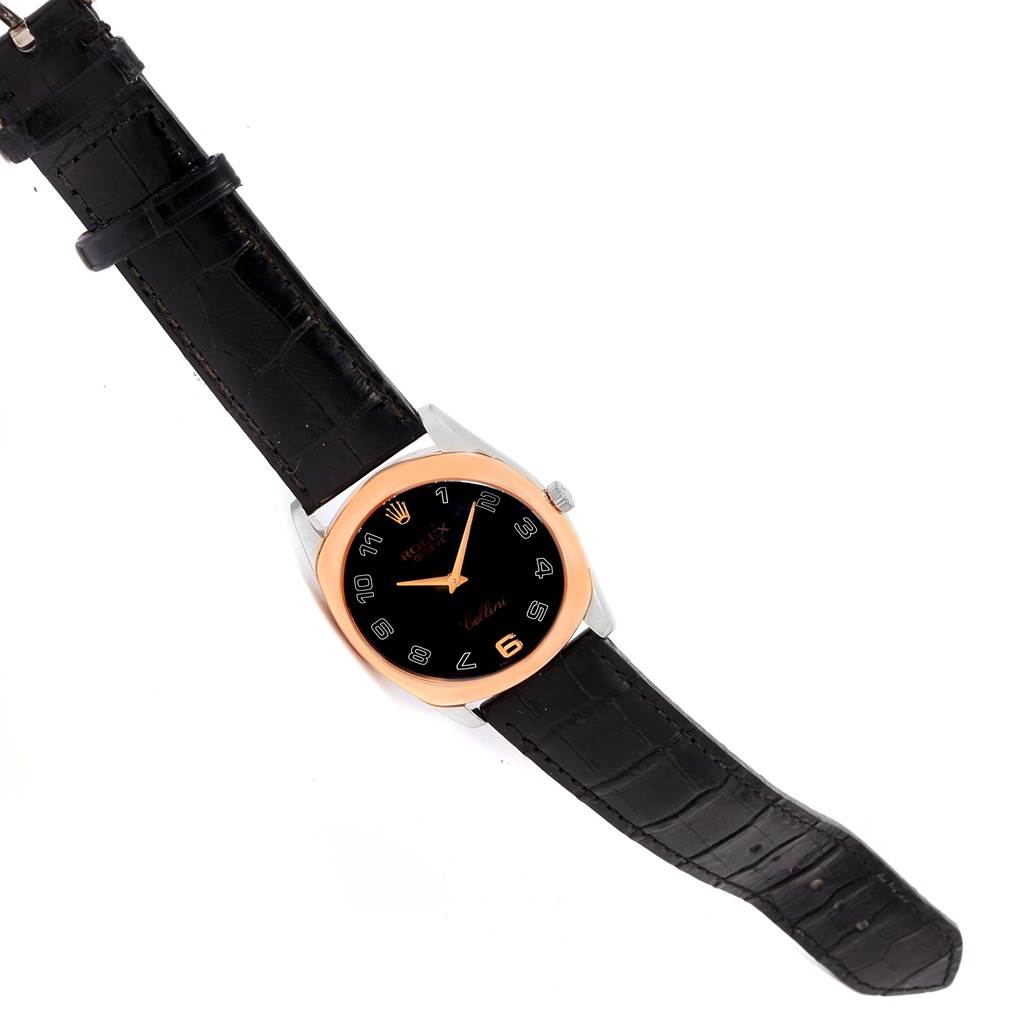 The image shows a top view of the Rolex Cellini 4233 White Gold Black Dial 4233 White Gold Black Dial watch with a black leather strap and a black dial encased in a rose gold bezel.