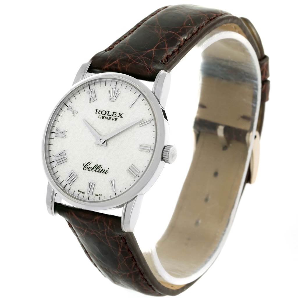 The Rolex Cellini 5116 White Gold Silver Dial 5116 White Gold Silver Dial watch is shown at an angle displaying the face, bezel, crown, and leather strap.