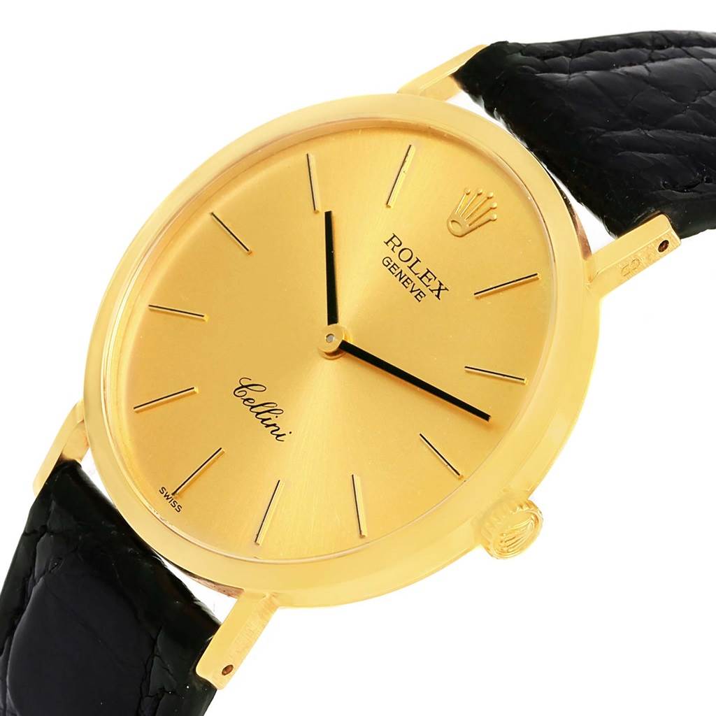 The image shows a Rolex Cellini 4112 Yellow Gold Champagne Dial 4112 Yellow Gold Champagne Dial watch at an angled view, highlighting its gold case, black strap, and detailed face.