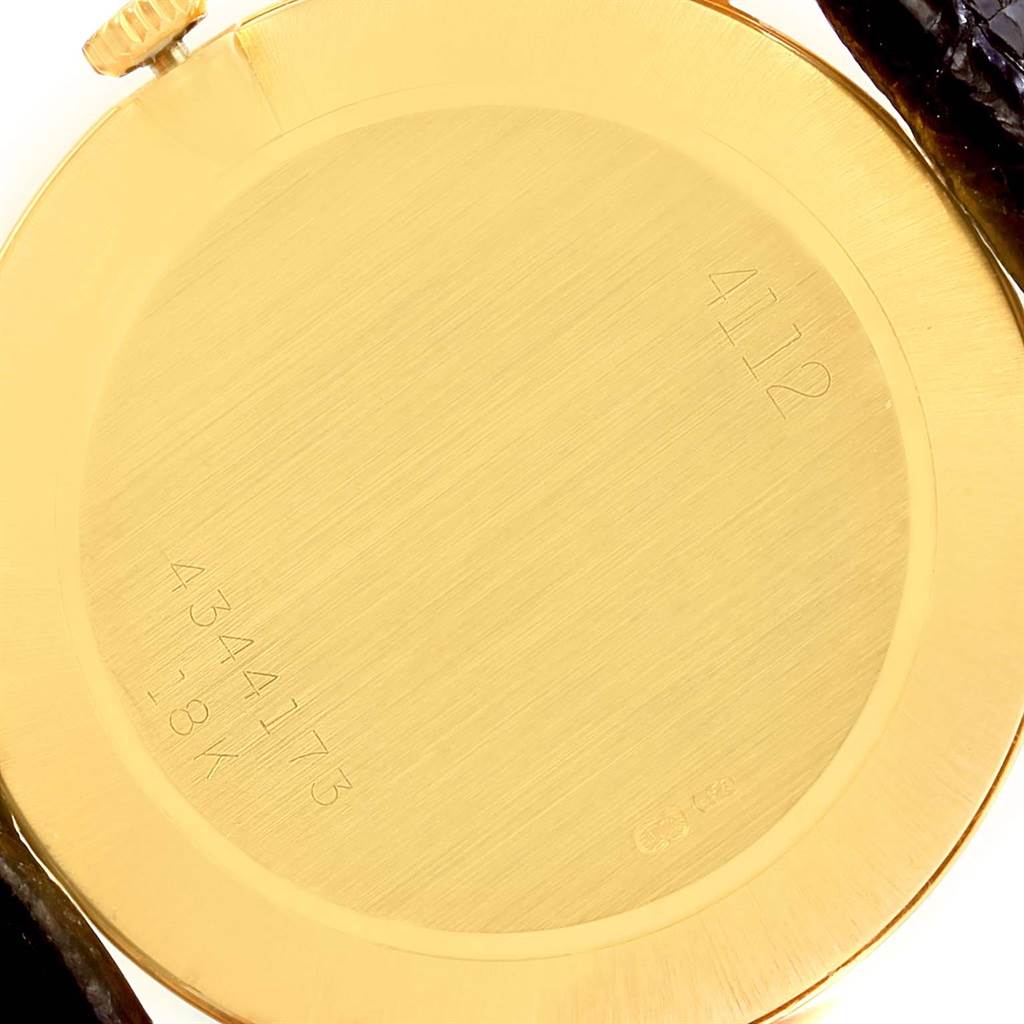 The image shows the back case of a Rolex Cellini 4112 Yellow Gold Champagne Dial 4112 Yellow Gold Champagne Dial watch, showcasing its gold surface and inscribed model numbers.