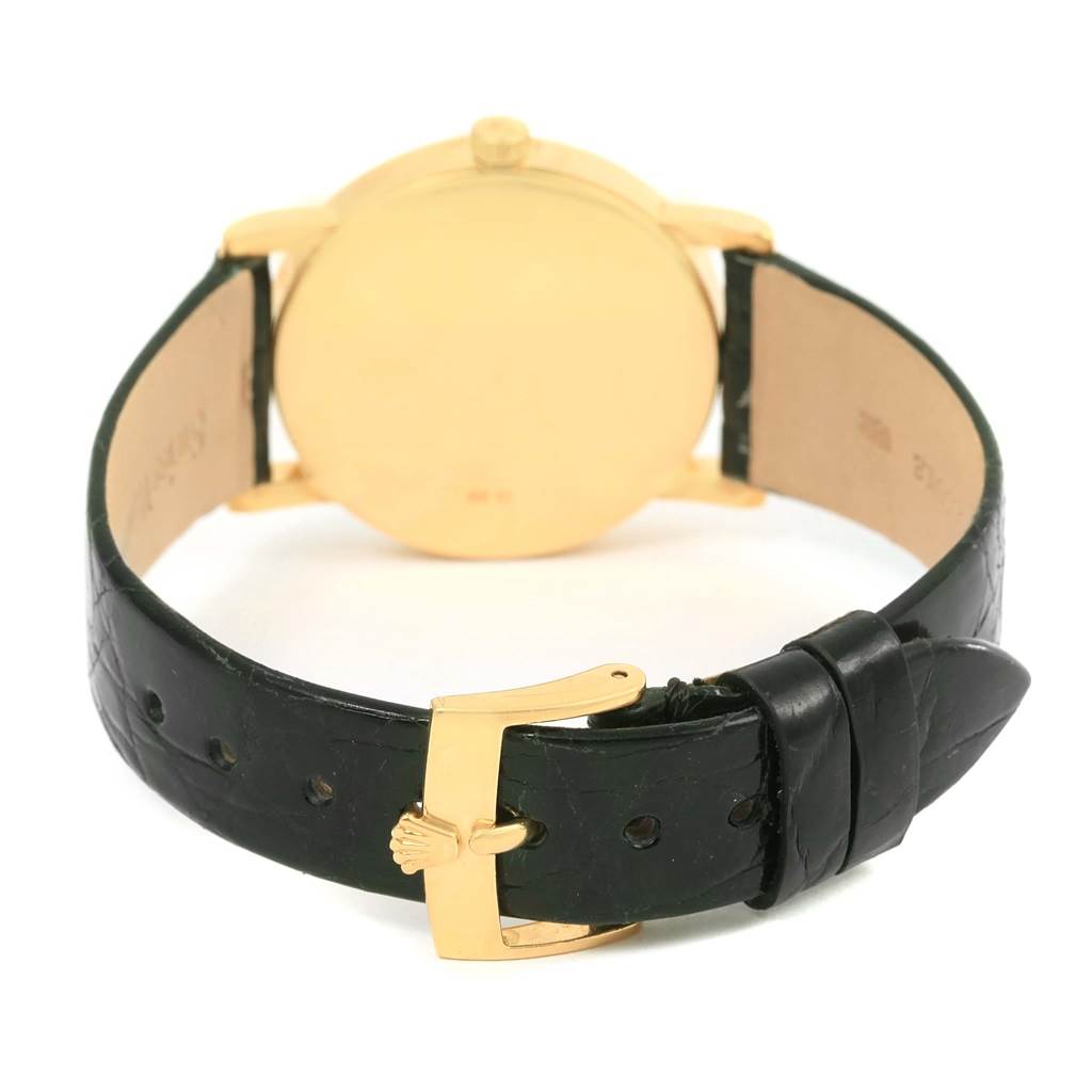 The image shows the back of a Rolex Cellini 5115 Yellow Gold Beige Dial 5115 Yellow Gold Beige Dial watch, focusing on the gold case, crown, and black leather strap with a gold buckle.