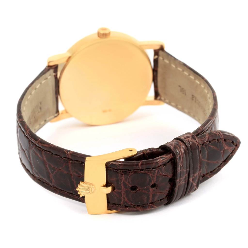 The image shows the back view of a Rolex Cellini 5115 Men's Yellow Gold Grey Dial 5115 Men's Yellow Gold Grey Dial watch, highlighting the case back and leather strap with a clasp.