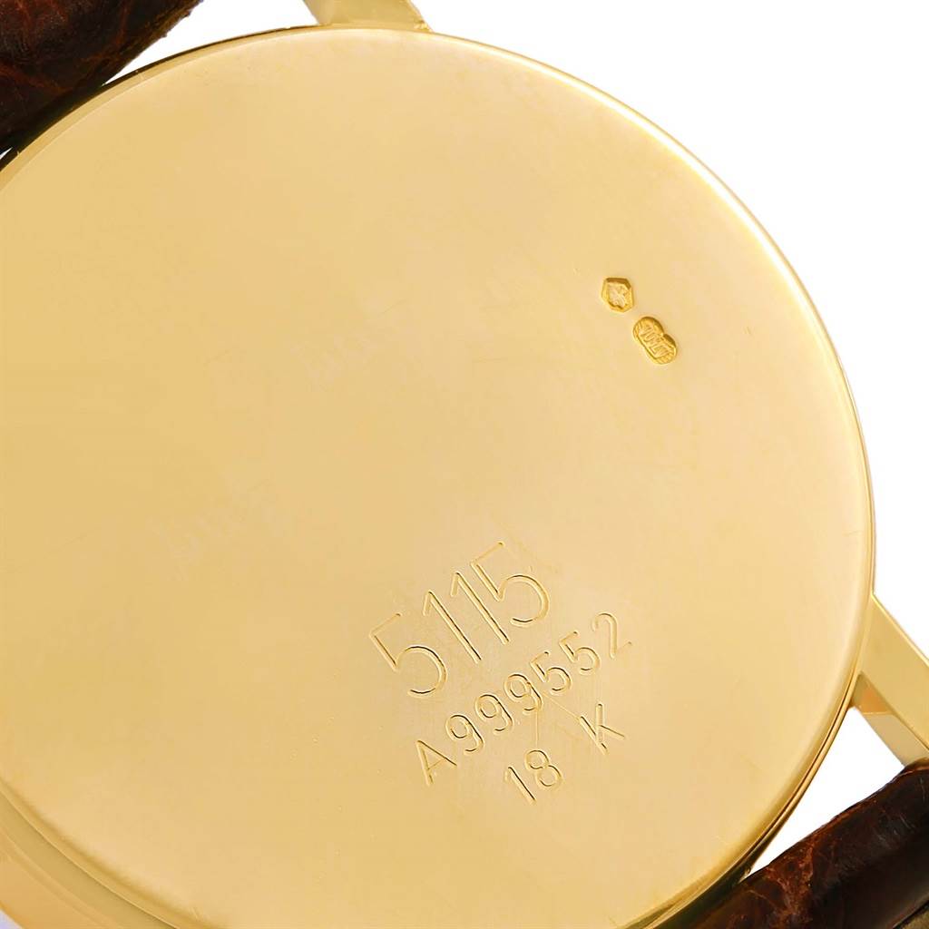 The image shows the back of a Rolex Cellini 5115 Men's Yellow Gold Grey Dial 5115 Men's Yellow Gold Grey Dial watch, showcasing its model number, serial number, and 18k gold mark.