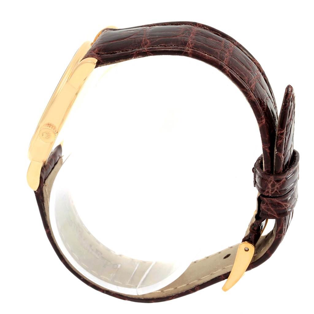 This side profile view of the Rolex Cellini 5115 Men's Yellow Gold Grey Dial 5115 Men's Yellow Gold Grey Dial watch shows its gold case and brown leather strap with buckle.