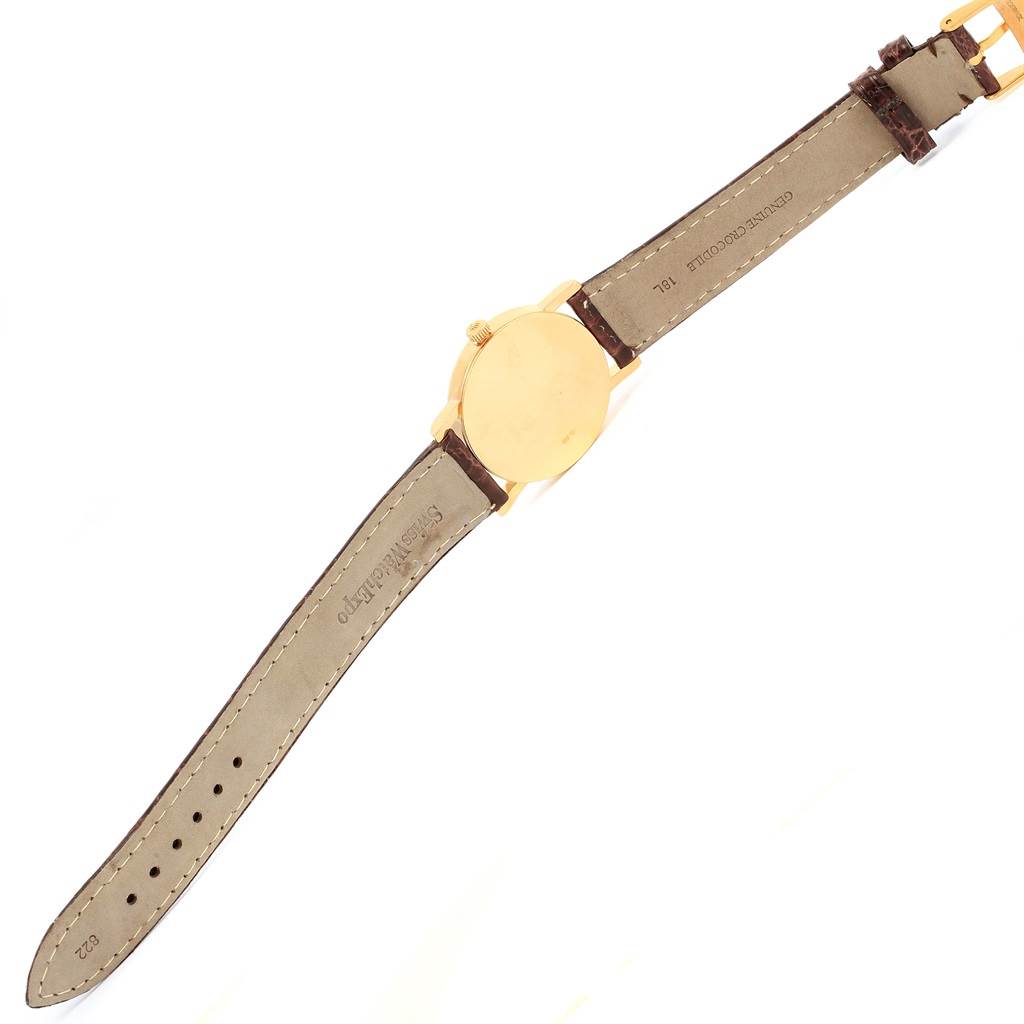 The image shows the back of a Rolex Cellini 5115 Men's Yellow Gold Grey Dial 5115 Men's Yellow Gold Grey Dial watch and its leather strap laid flat.