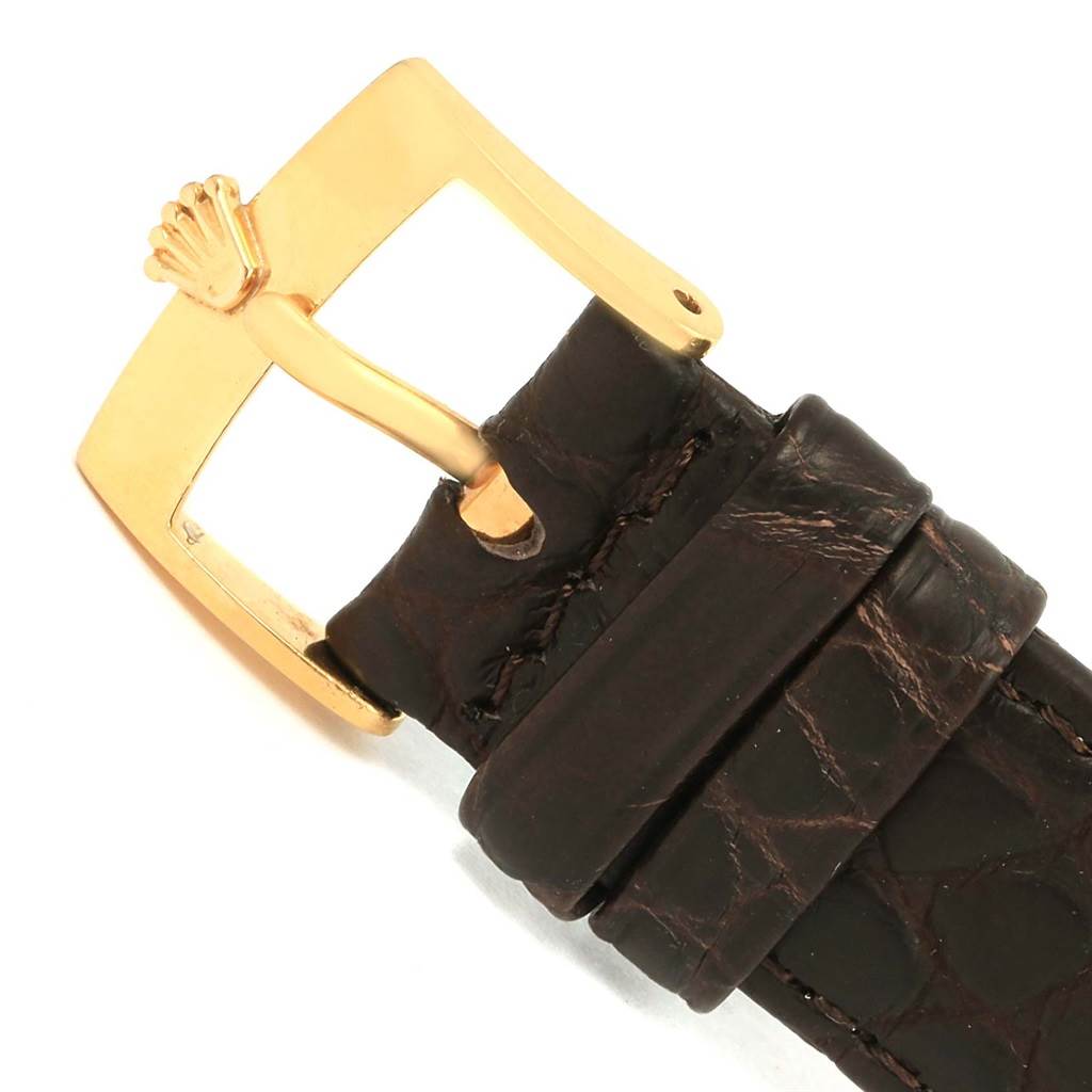 This image shows the gold buckle and part of the brown leather strap from a Rolex Cellini 5116 Men's Yellow Gold Champagne Dial 5116 Men's Yellow Gold Champagne Dial watch.