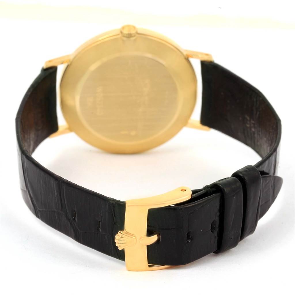 The image shows a rear angle of a Rolex Cellini 4112 Men's Yellow Gold Grey Dial 4112 Men's Yellow Gold Grey Dial watch, highlighting the gold back case and black leather strap with a gold buckle.