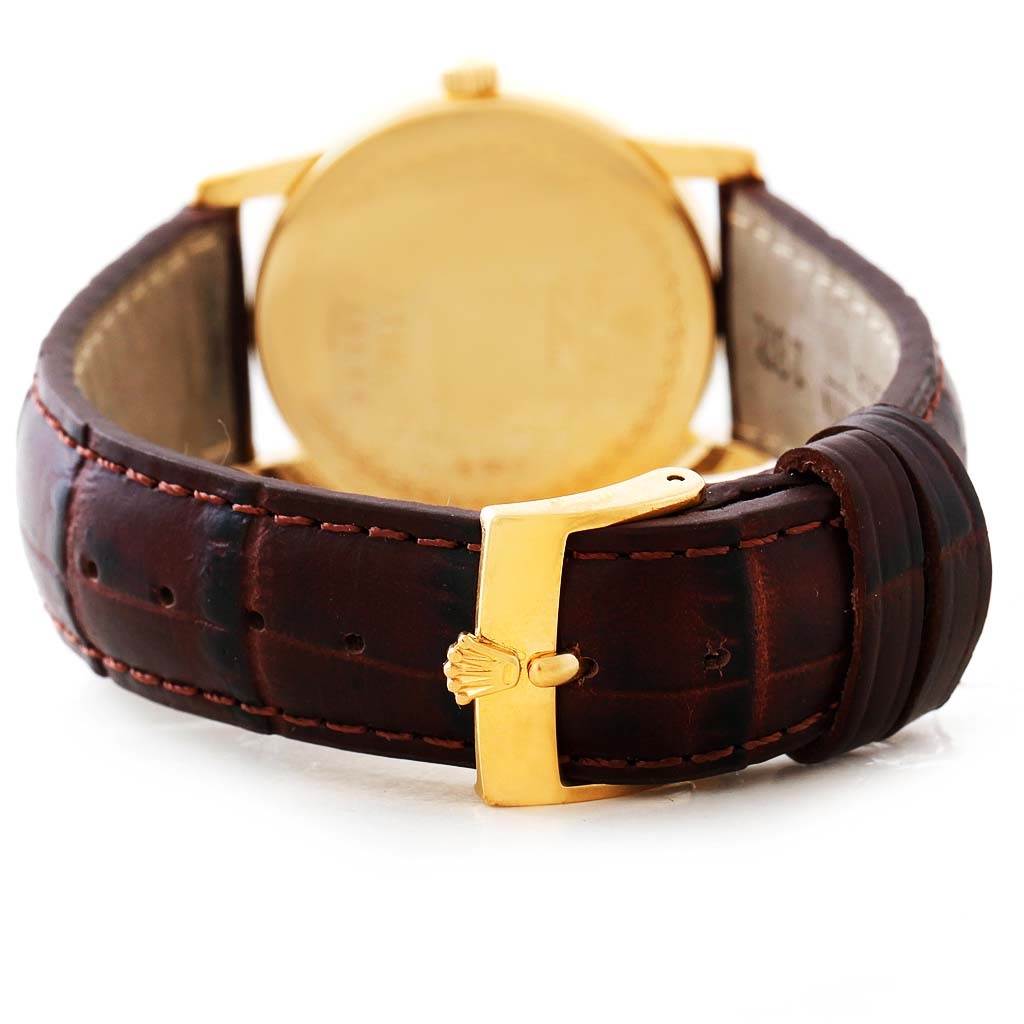 The image shows a rear view of the Rolex Cellini 5116 Men's Yellow Gold Beige Dial 5116 Men's Yellow Gold Beige Dial watch, highlighting its brown leather strap and gold buckle.