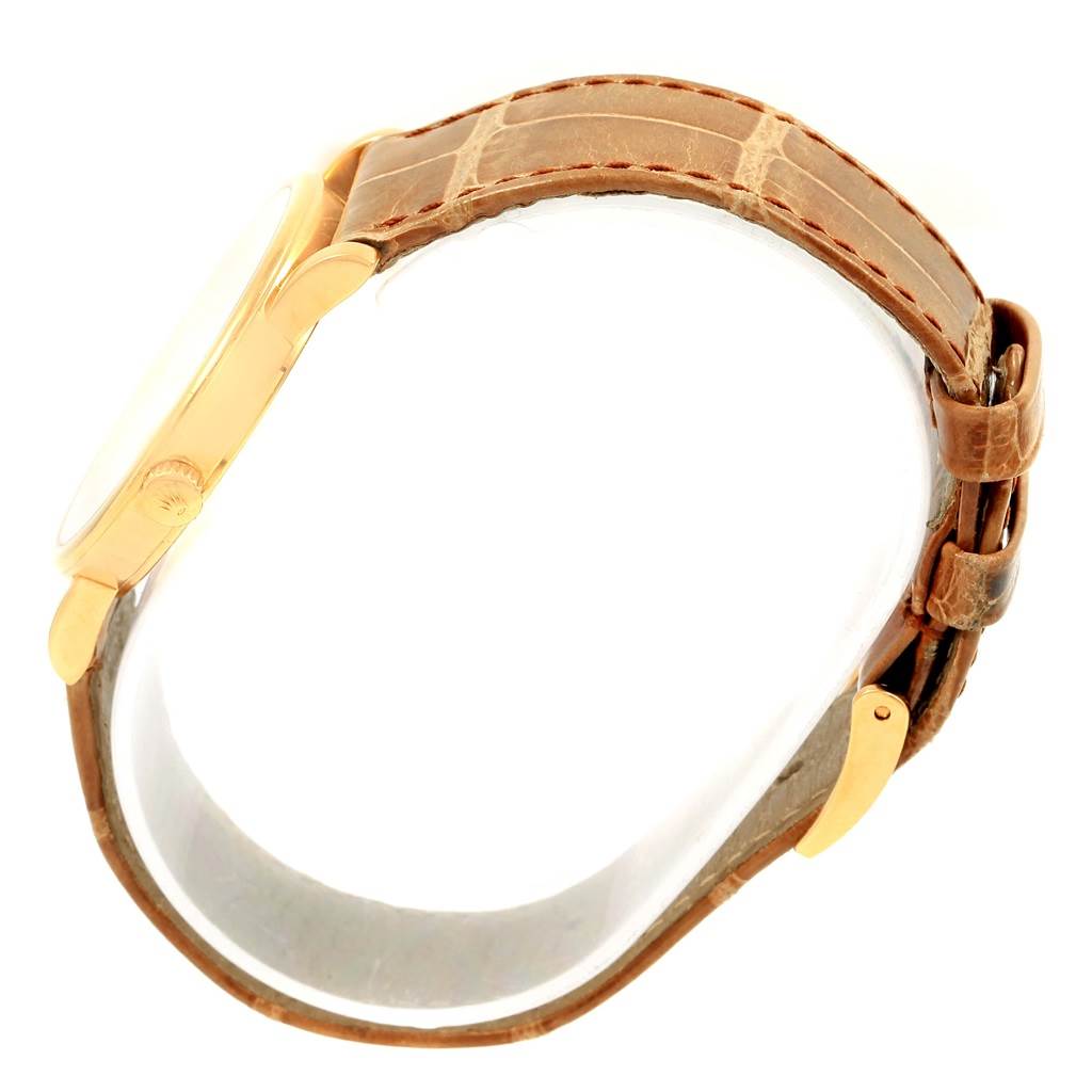 The image shows a side angle of a Rolex Cellini 5115 Yellow Gold Mother of Pearl Dial 5115 Yellow Gold Mother of Pearl Dial watch, focusing on its brown leather strap and gold case with the crown visible.