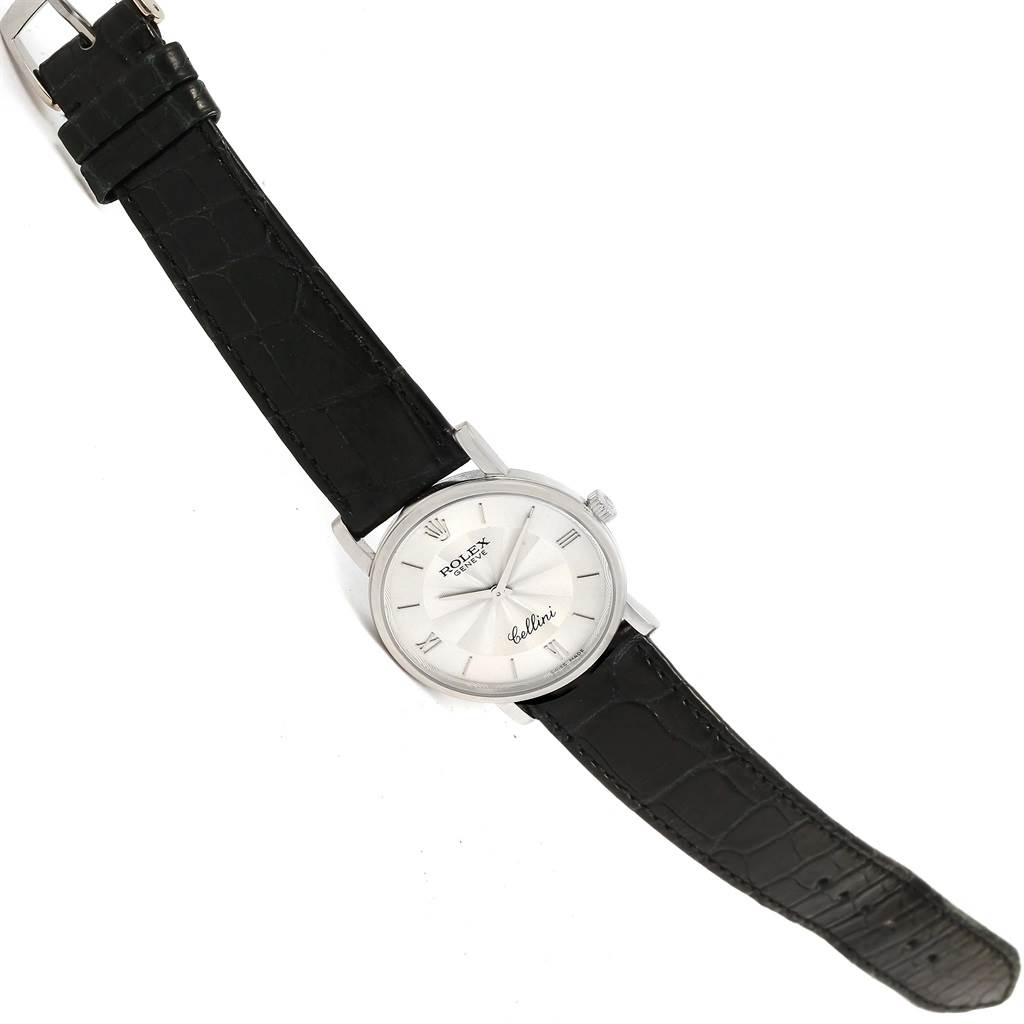 The Rolex Cellini 5115 White Gold Silver Dial 5115 White Gold Silver Dial watch is shown from a top-down angle, featuring its dial, crown, and black leather strap.