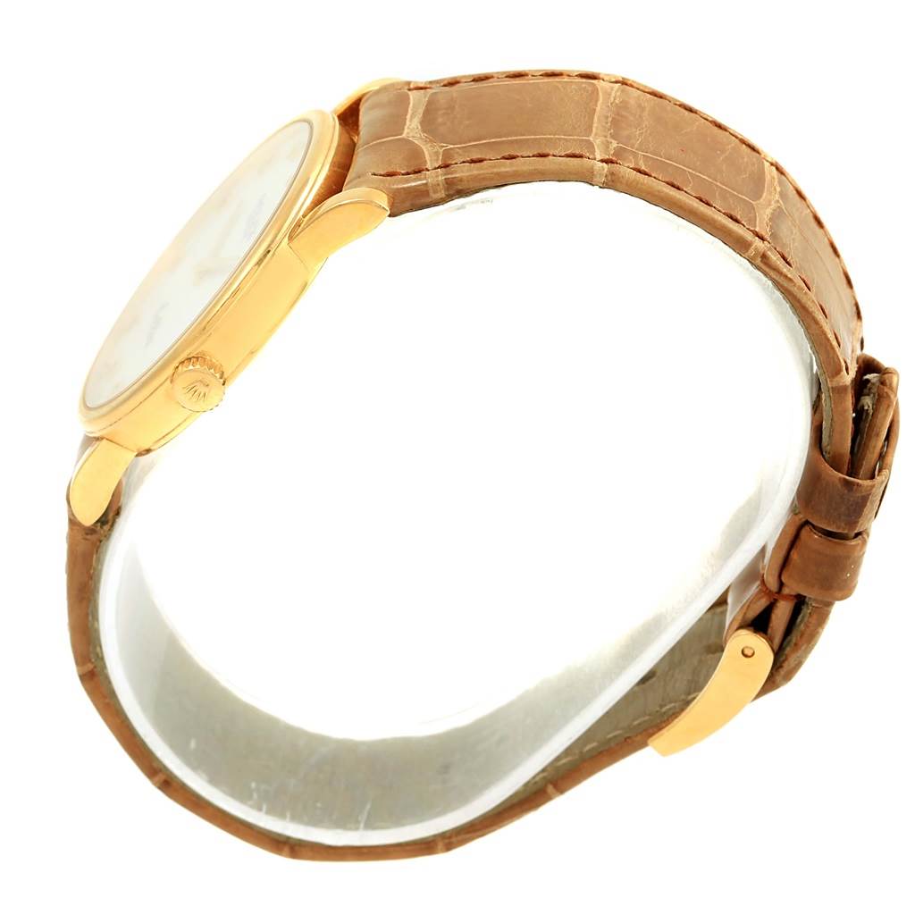 The image shows a side view of a Rolex Cellini 5115 Yellow Gold Mother of Pearl Dial 5115 Yellow Gold Mother of Pearl Dial watch, highlighting its gold case, crown, and brown leather strap.