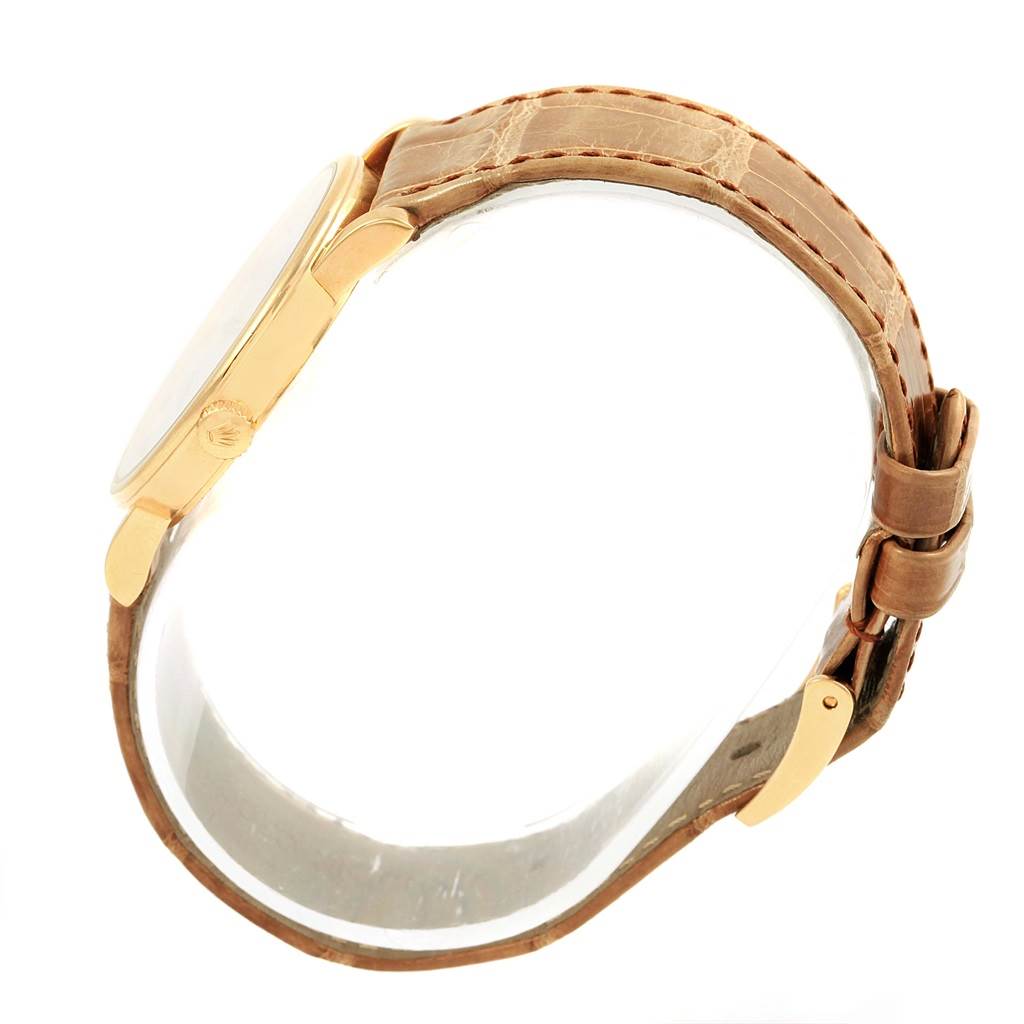 The Rolex Cellini 5115 Yellow Gold Mother of Pearl Dial 5115 Yellow Gold Mother of Pearl Dial watch is shown from a side angle, highlighting the case, crown, and leather strap.