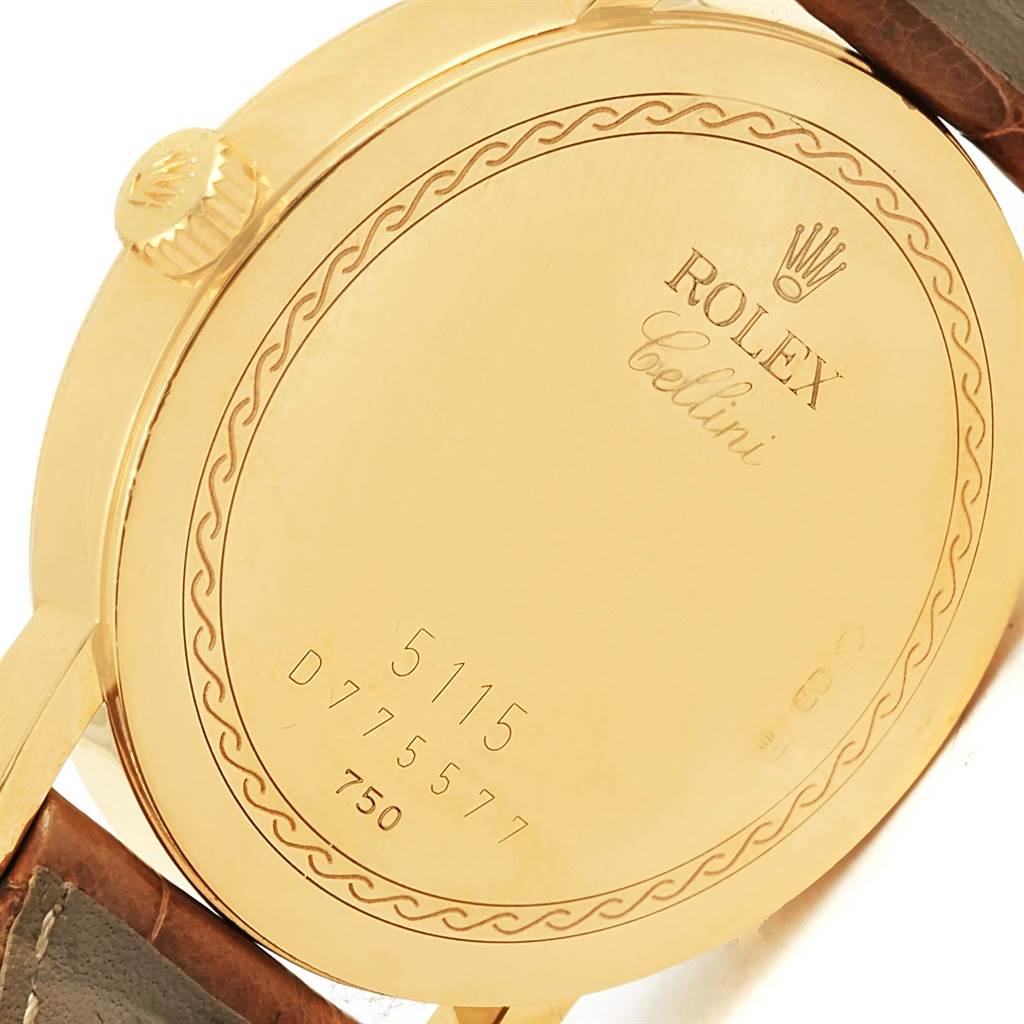 The image shows the back of a Rolex Cellini 5115 Yellow Gold Mother of Pearl Dial 5115 Yellow Gold Mother of Pearl Dial watch, displaying its engravings and part of the leather strap.