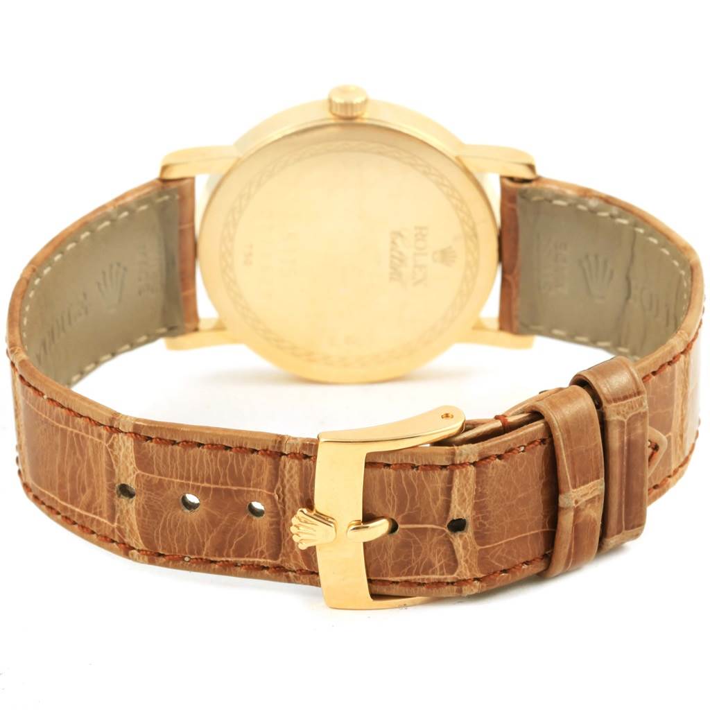 The image shows the back of a Rolex Cellini 5115 Yellow Gold Mother of Pearl Dial 5115 Yellow Gold Mother of Pearl Dial watch, highlighting the case back and brown leather strap with a gold buckle.