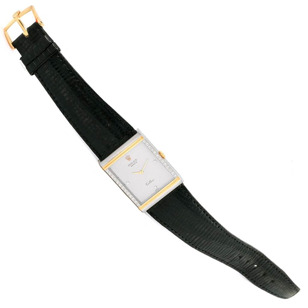 This Rolex Cellini 4127 Men's Yellow Gold Silver Dial 4127 Men's Yellow Gold Silver Dial watch is shown from a top-down angle, featuring its rectangular face, black strap, and gold buckle.