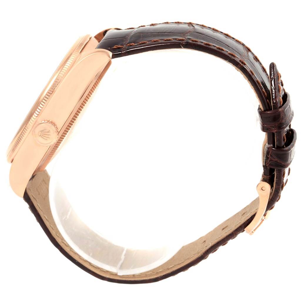 This side view of the Rolex Cellini 50515 Men's Rose Gold Silver Dial 50515 Men's Rose Gold Silver Dial watch shows its case, crown, and leather strap with a buckle.