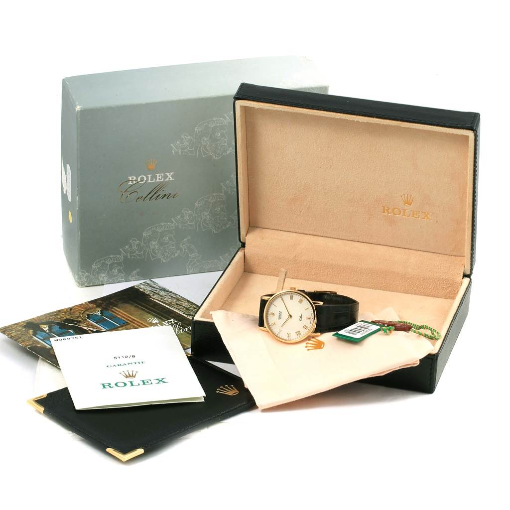 The image shows a Rolex Cellini 5112 Men
s Beige Dial 5112 Men
s Beige Dial watch in its case, along with a box, manual, brochures, and a cleaning cloth.