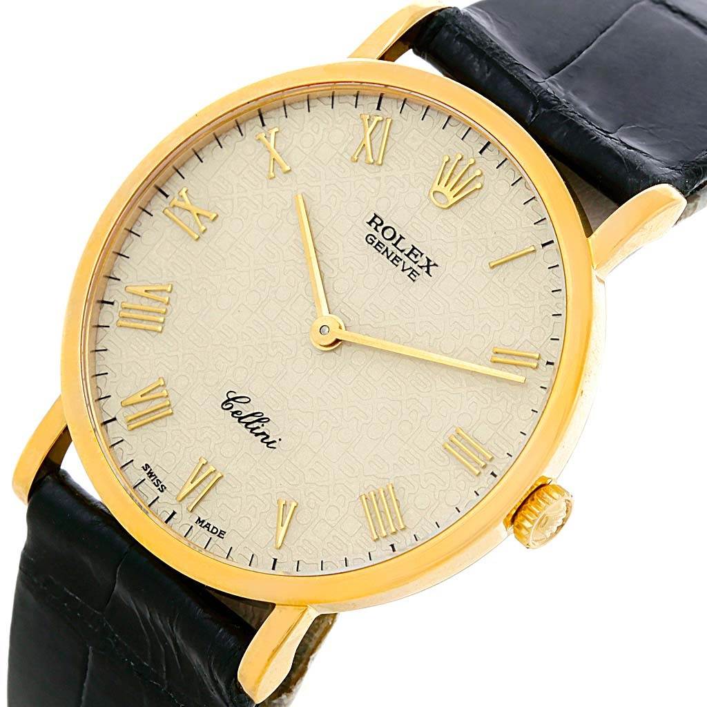 This image shows a Rolex Cellini 5112 Men
s Beige Dial 5112 Men
s Beige Dial watch from a slight angled perspective, featuring its dial, gold case, and black leather strap.