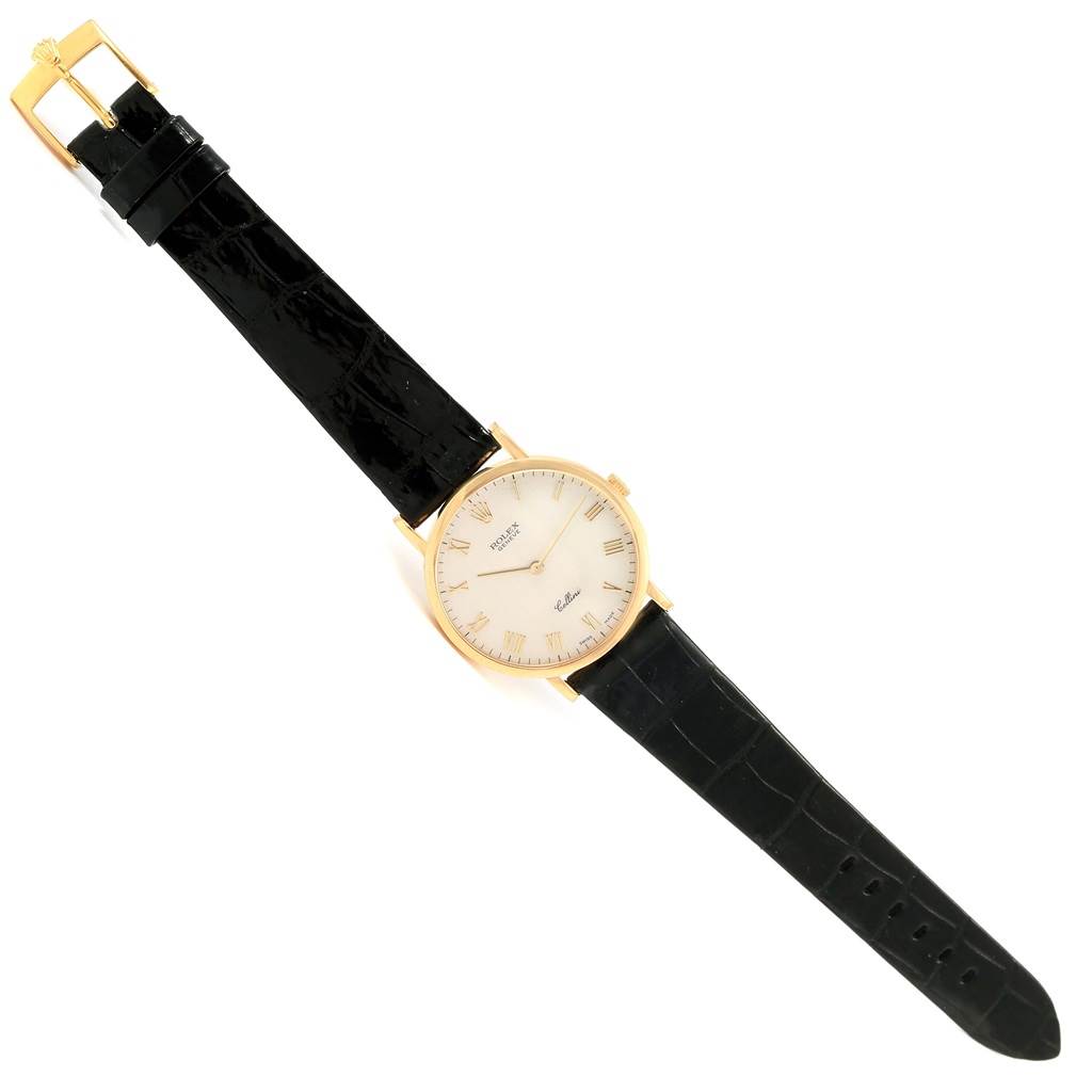 The Rolex Cellini 5112 Men's Yellow Gold Beige Dial 5112 Men's Yellow Gold Beige Dial watch is shown from a top view, displaying the face, black leather strap, and gold buckle.