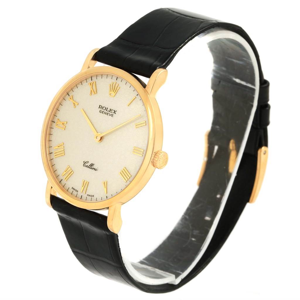The Rolex Cellini 5112 Men's Yellow Gold Beige Dial 5112 Men's Yellow Gold Beige Dial watch is shown from an angled side view, displaying the face, gold case, black leather strap, and crown.