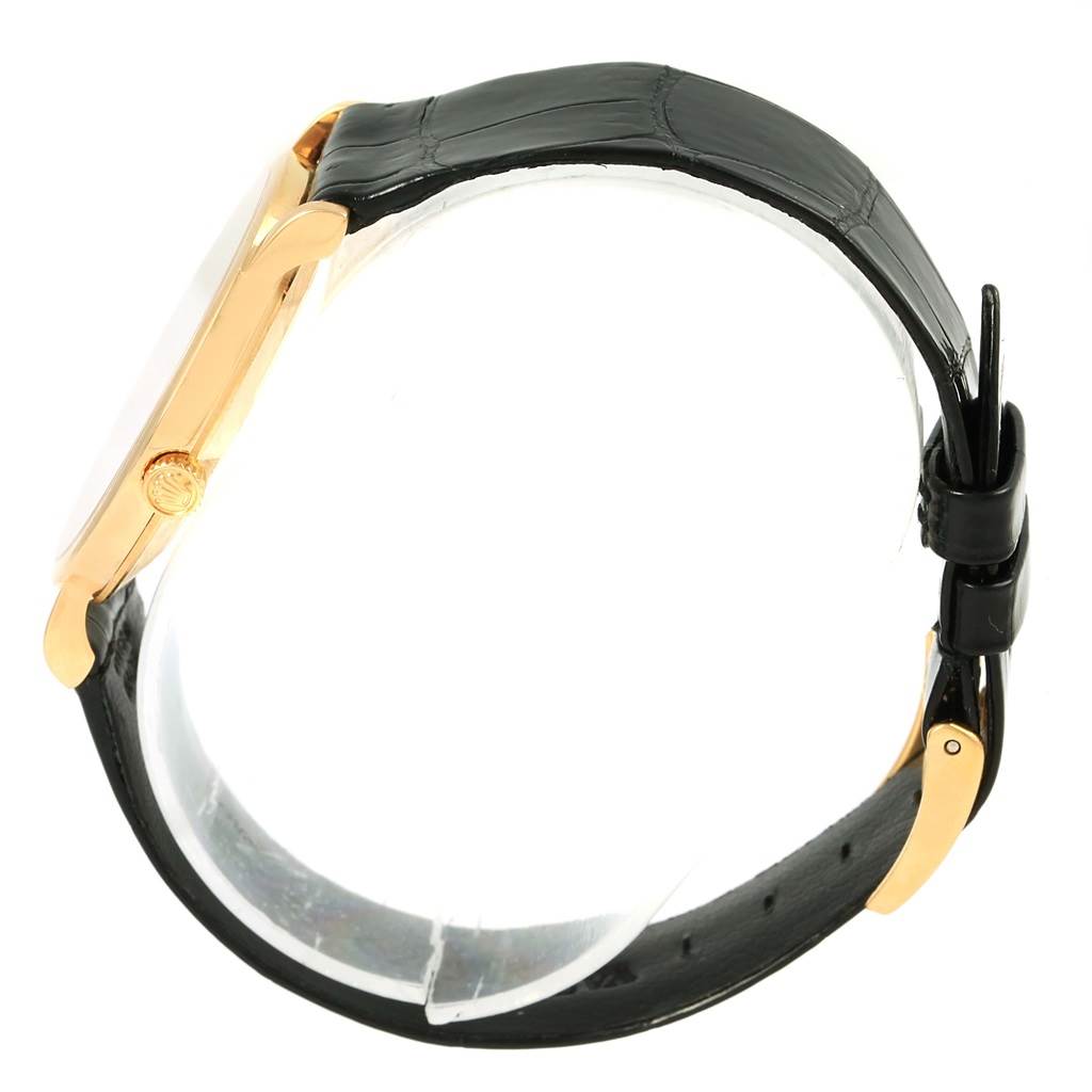 The Rolex Cellini 5112 Men's Yellow Gold Beige Dial 5112 Men's Yellow Gold Beige Dial watch is shown from its side, displaying the case, crown, and black leather strap with buckle.