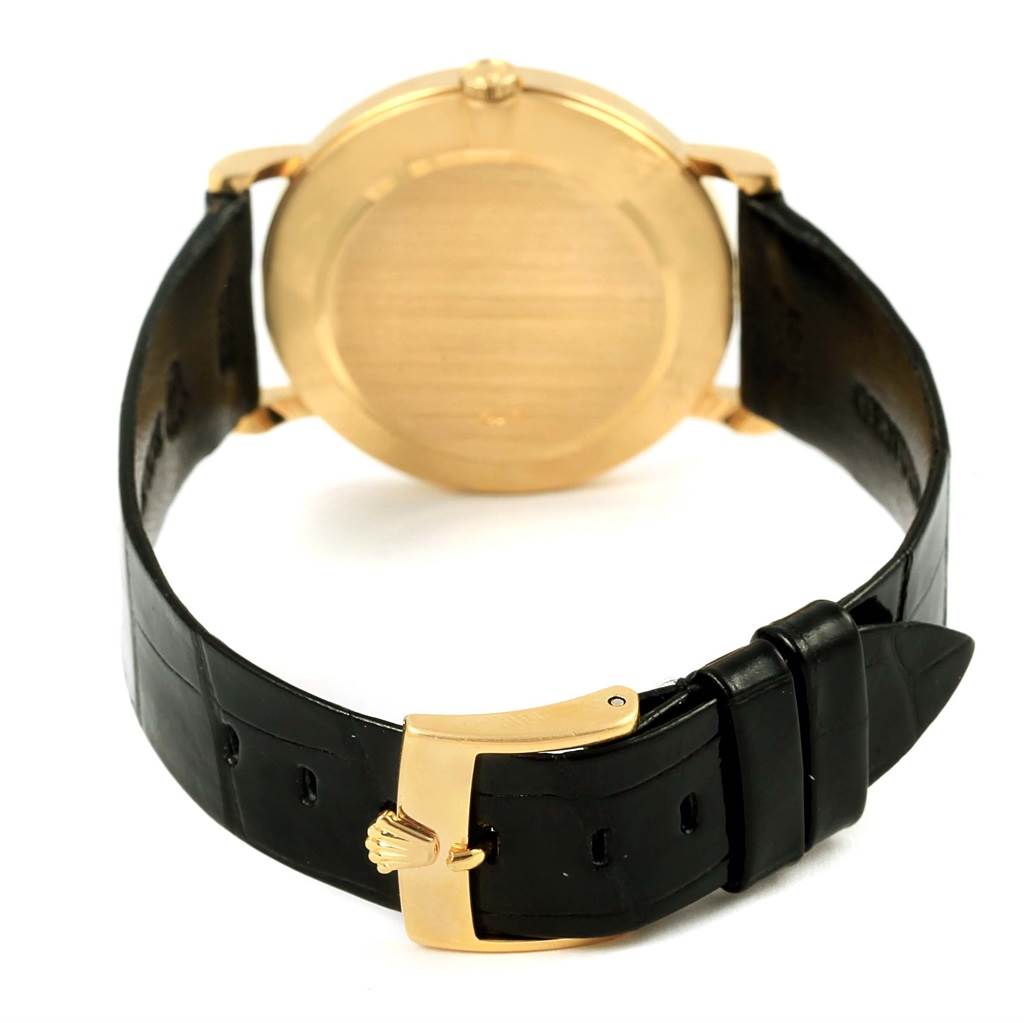 This image shows the back side of a Rolex Cellini 5112 Men's Yellow Gold Beige Dial 5112 Men's Yellow Gold Beige Dial watch, focusing on the gold case back and black leather strap with a gold buckle.