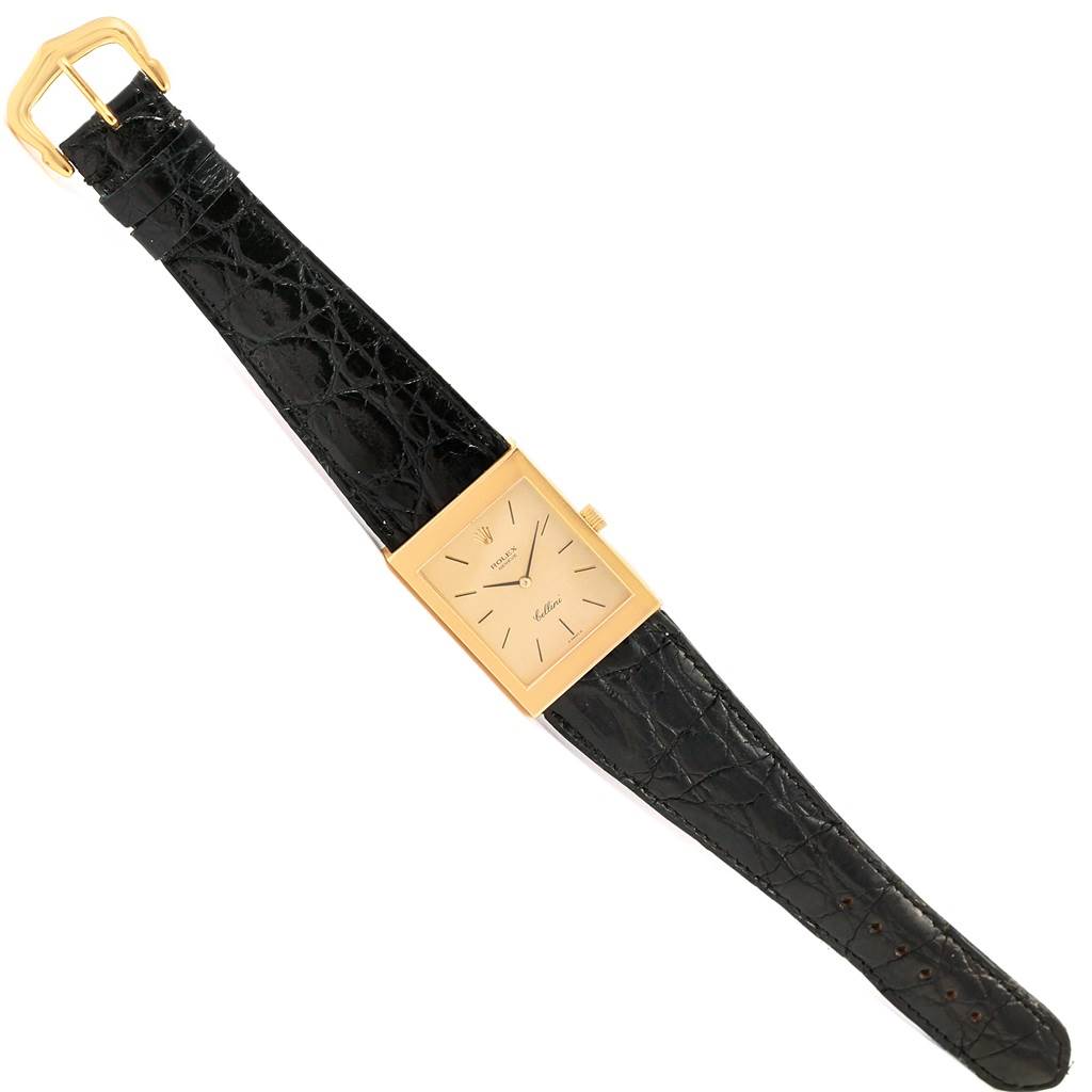 The Rolex Cellini 4027 Men
s Yellow Gold Champagne Dial 4027 Men
s Yellow Gold Champagne Dial model watch is shown from a top-down angle, highlighting its rectangular face and black leather strap.