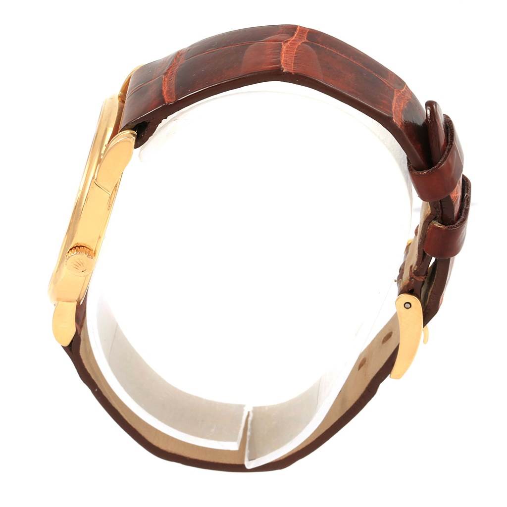 The image shows a side view of a Rolex Cellini 5116 Yellow Gold Mother of Pearl Dial 5116 Yellow Gold Mother of Pearl Dial watch with a gold case and brown leather strap.