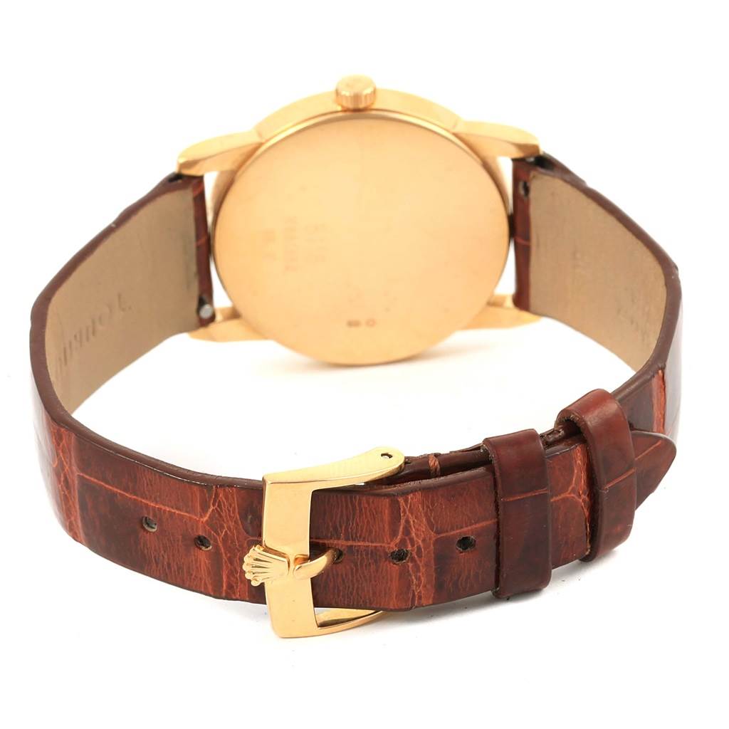 The image shows the back case and buckle of a Cellini model by Rolex, displaying a leather strap and a gold-tone buckle.