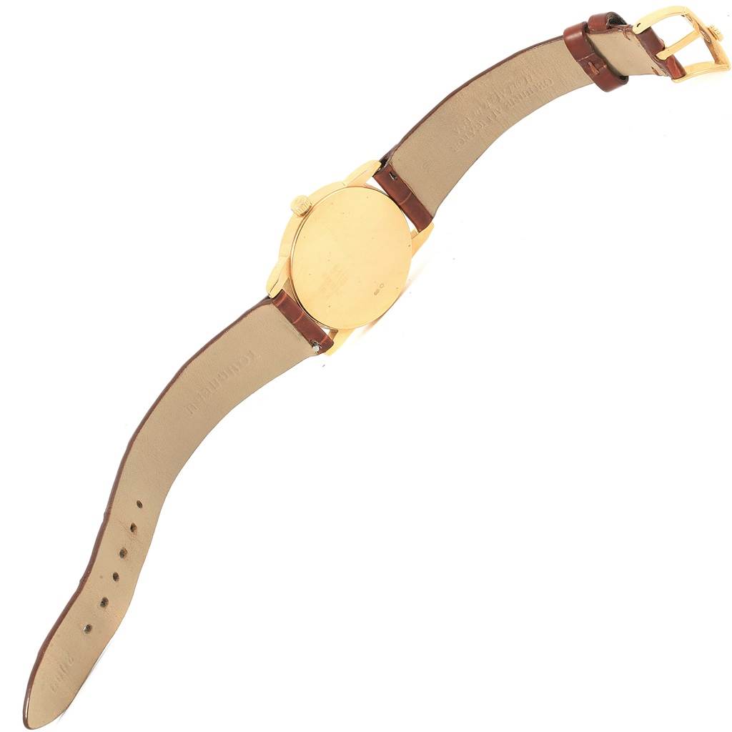 The image shows the backside of a Rolex Cellini 5116 Yellow Gold Mother of Pearl Dial 5116 Yellow Gold Mother of Pearl Dial watch, including its gold case and leather strap.