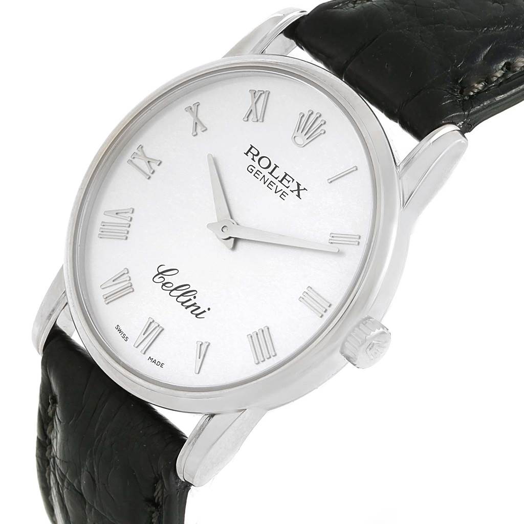 This image shows a Rolex Cellini 5116 Men
s White Gold Silver Dial 5116 Men
s White Gold Silver Dial watch from an angled frontal view, highlighting its white dial, Roman numerals, and black leather strap.