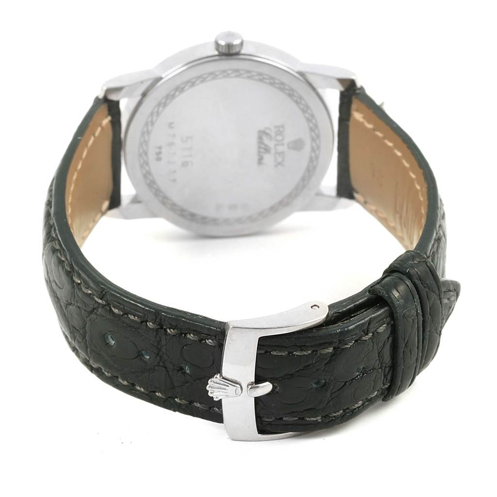 The image shows the back of a Rolex Cellini 5116 Men
s White Gold Silver Dial 5116 Men
s White Gold Silver Dial watch and part of its black leather strap with a silver buckle.