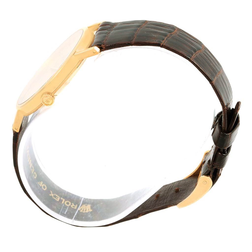 This image shows a Rolex Cellini 5112 Yellow Gold Champagne Dial 5112 Yellow Gold Champagne Dial watch from the side, highlighting the golden case, crown, and leather strap.