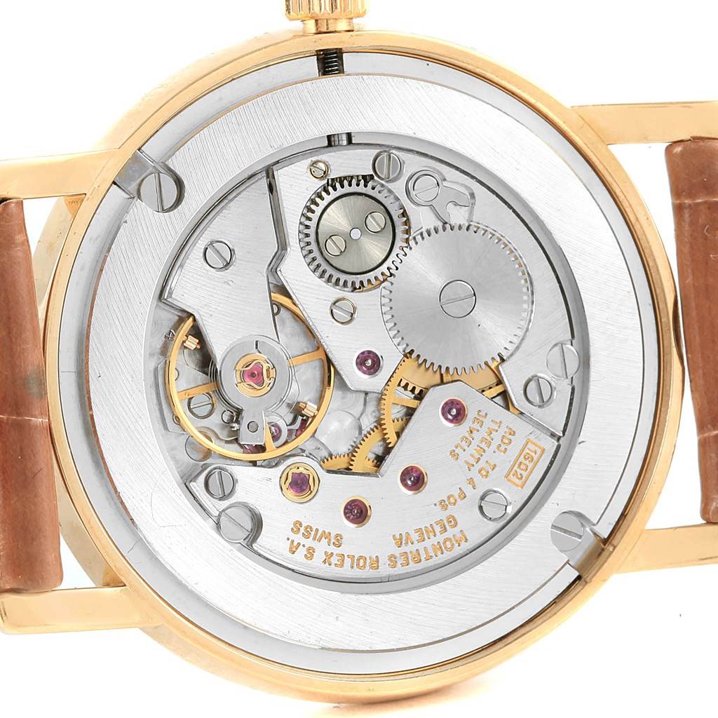 The image shows a close-up of the back of the Rolex Cellini 5115 Men's Yellow Gold Beige Dial 5115 Men's Yellow Gold Beige Dial watch, revealing its internal mechanical parts and gears.