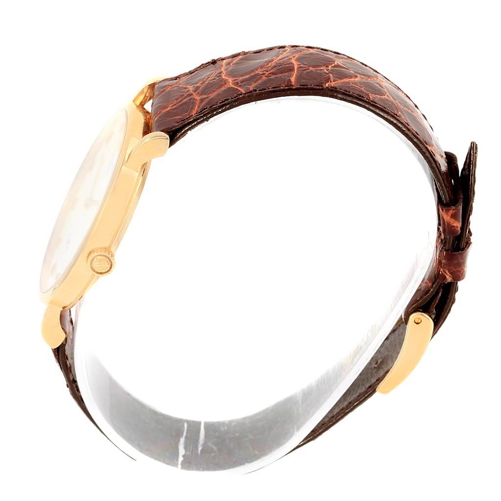 The Rolex Cellini 5112 Yellow Gold Mother of Pearl Dial 5112 Yellow Gold Mother of Pearl Dial model watch is shown from a side angle, highlighting its gold case, crown, and brown leather strap.