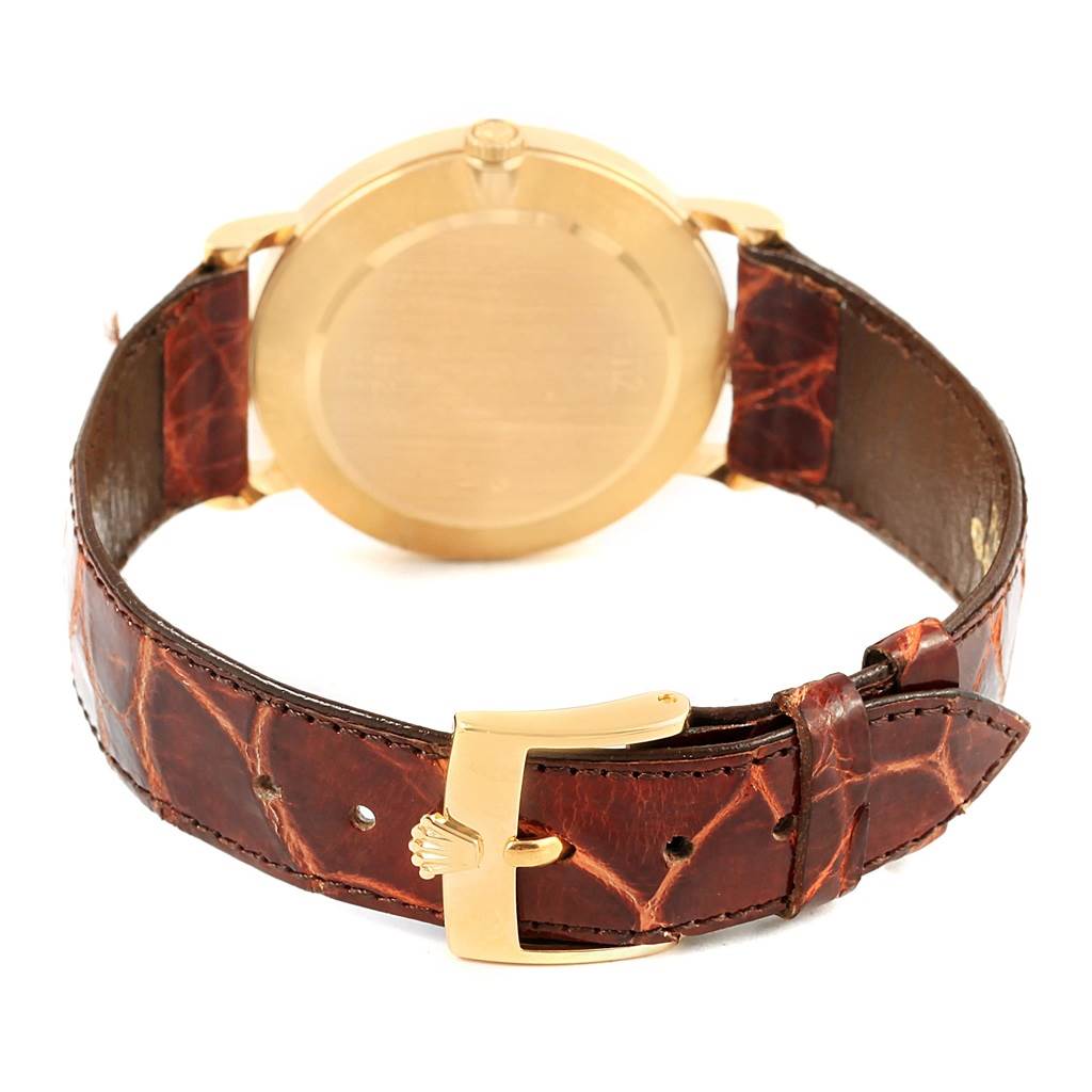 The image shows the back of a Rolex Cellini 5112 Yellow Gold Mother of Pearl Dial 5112 Yellow Gold Mother of Pearl Dial watch, highlighting its gold case and brown leather strap with a gold buckle.