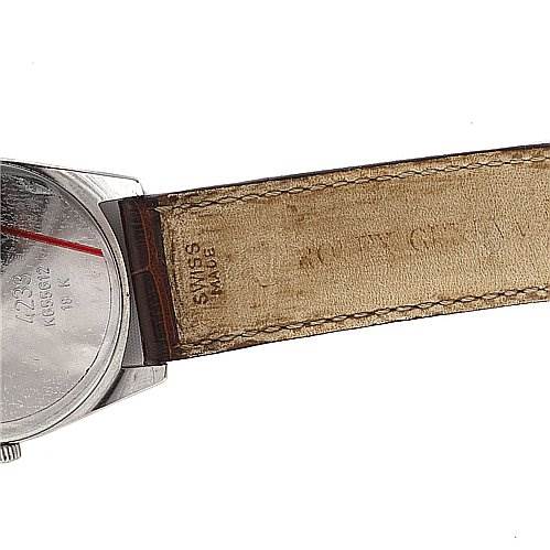 The image shows a close-up side view of the Rolex Cellini 4233 White Gold Black Dial 4233 White Gold Black Dial watch, focusing on part of the watch case and the leather strap.