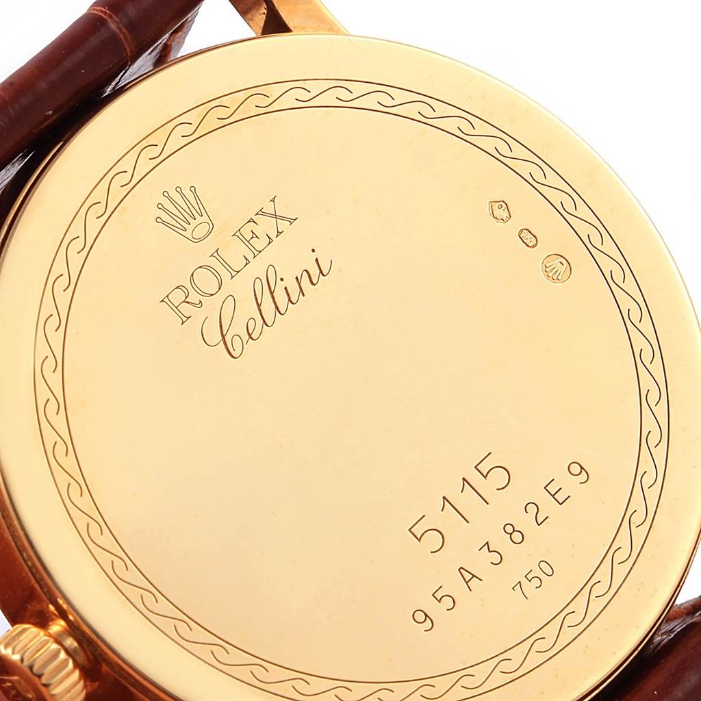 This image shows the back case of a Rolex Cellini 5115 Men's Yellow Gold Beige Dial 5115 Men's Yellow Gold Beige Dial watch with its engravings and a portion of the leather strap.