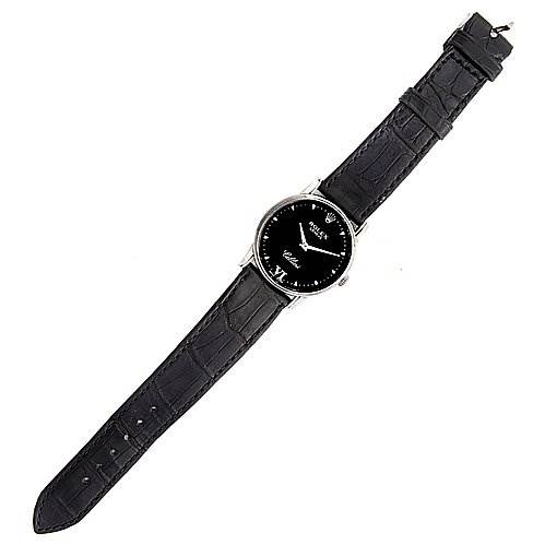 The Rolex Cellini 5116/9 White Gold Black Dial 5116/9 White Gold Black Dial watch is shown from a top-down angle, displaying its black face, silver case, and black leather strap.