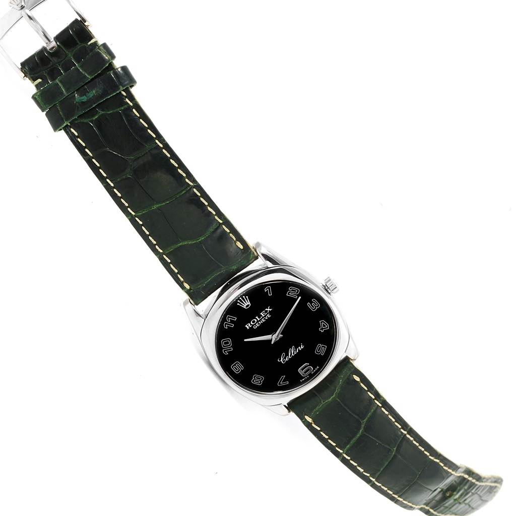 This image shows a top-down view of a Rolex Cellini 4233 Men's White Gold Black Dial 4233 Men's White Gold Black Dial watch, featuring its black dial, silver case, and dark green leather strap.