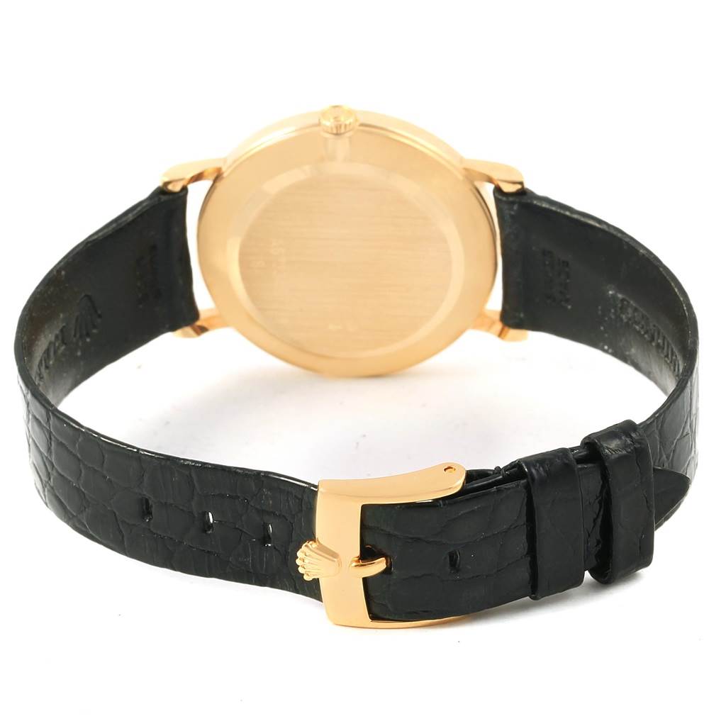 The image shows the back and side of a Rolex Cellini 5112 Men's Yellow Gold Beige Dial 5112 Men's Yellow Gold Beige Dial watch, featuring its gold case and black leather strap with a gold buckle.