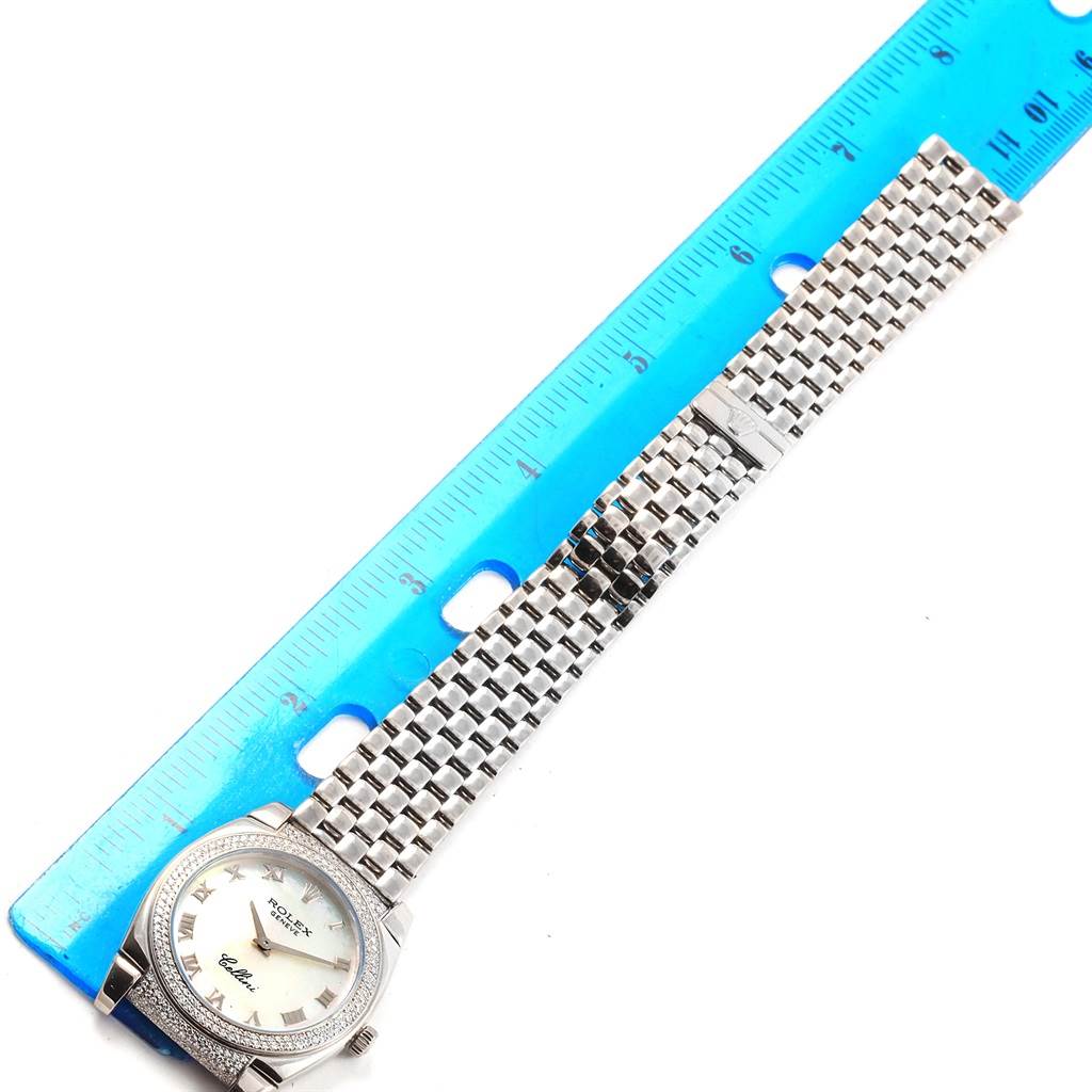 The image shows a top-down view of a Rolex Cellini 6321 Women's White Gold Mother of Pearl Dial 6321 Women's White Gold Mother of Pearl Dial watch next to a blue ruler, highlighting its face and metal bracelet.