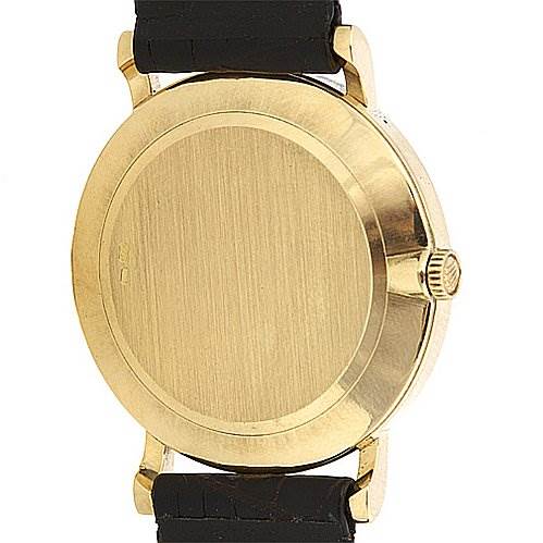 The image shows the back case view of a Rolex Cellini 5112 Yellow Gold Champagne Dial 5112 Yellow Gold Champagne Dial watch with a gold casing and black leather straps.