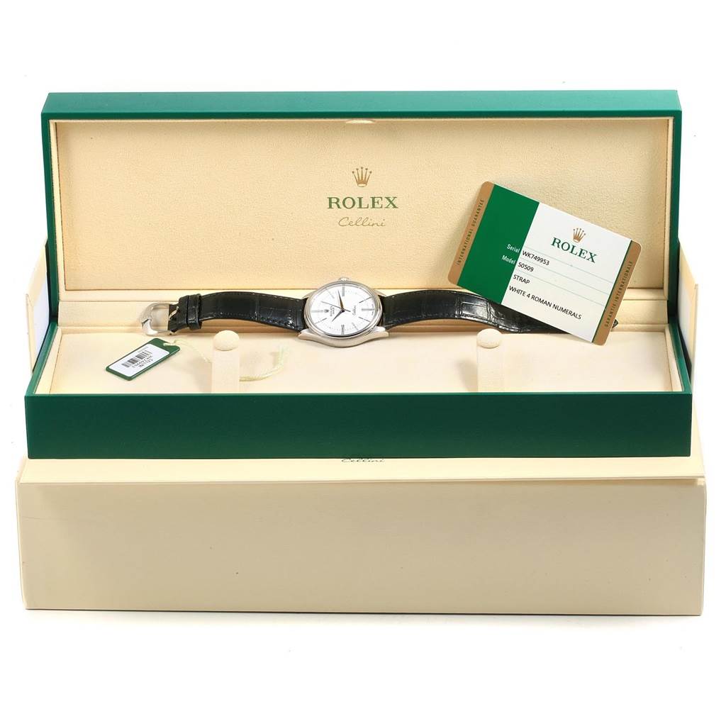 The image shows a Rolex Cellini 50509 Men
s White Gold White Dial 50509 Men
s White Gold White Dial watch placed in its open green and beige box, alongside a warranty card.