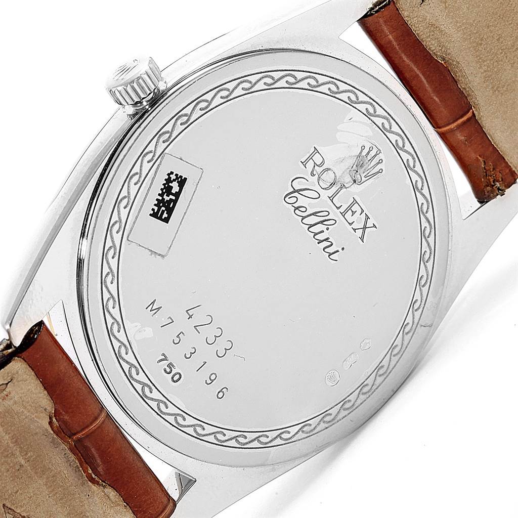 The image shows the back casing of a Rolex Cellini 4233 Men's White Gold Black Dial 4233 Men's White Gold Black Dial watch at an angle, featuring the model's details and a portion of the strap.