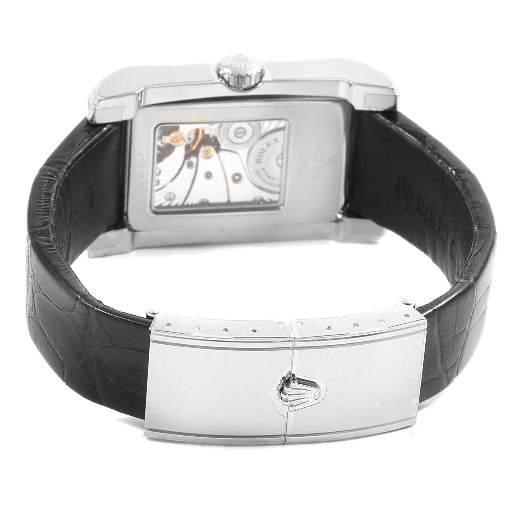 The image shows the backside of a Rolex Cellini 5443/9 Men
s White Gold Black Dial 5443/9 Men
s White Gold Black Dial watch, featuring the movement through a transparent case and a leather strap with a clasp.