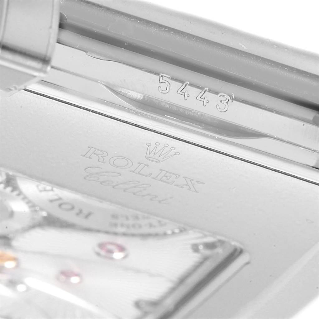 The image shows a close-up of the serial number, brand, and part of the movement of a Rolex Cellini 5443/9 Men
s White Gold Black Dial 5443/9 Men
s White Gold Black Dial watch.