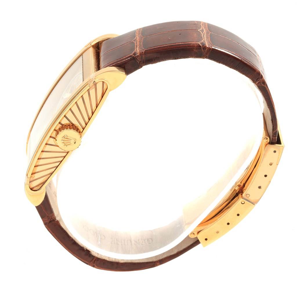 This side angle of the Rolex Cellini 5440/8 Men's Yellow Gold Champagne Dial 5440/8 Men's Yellow Gold Champagne Dial watch showcases its crown, bezel, and brown leather strap with a gold clasp.